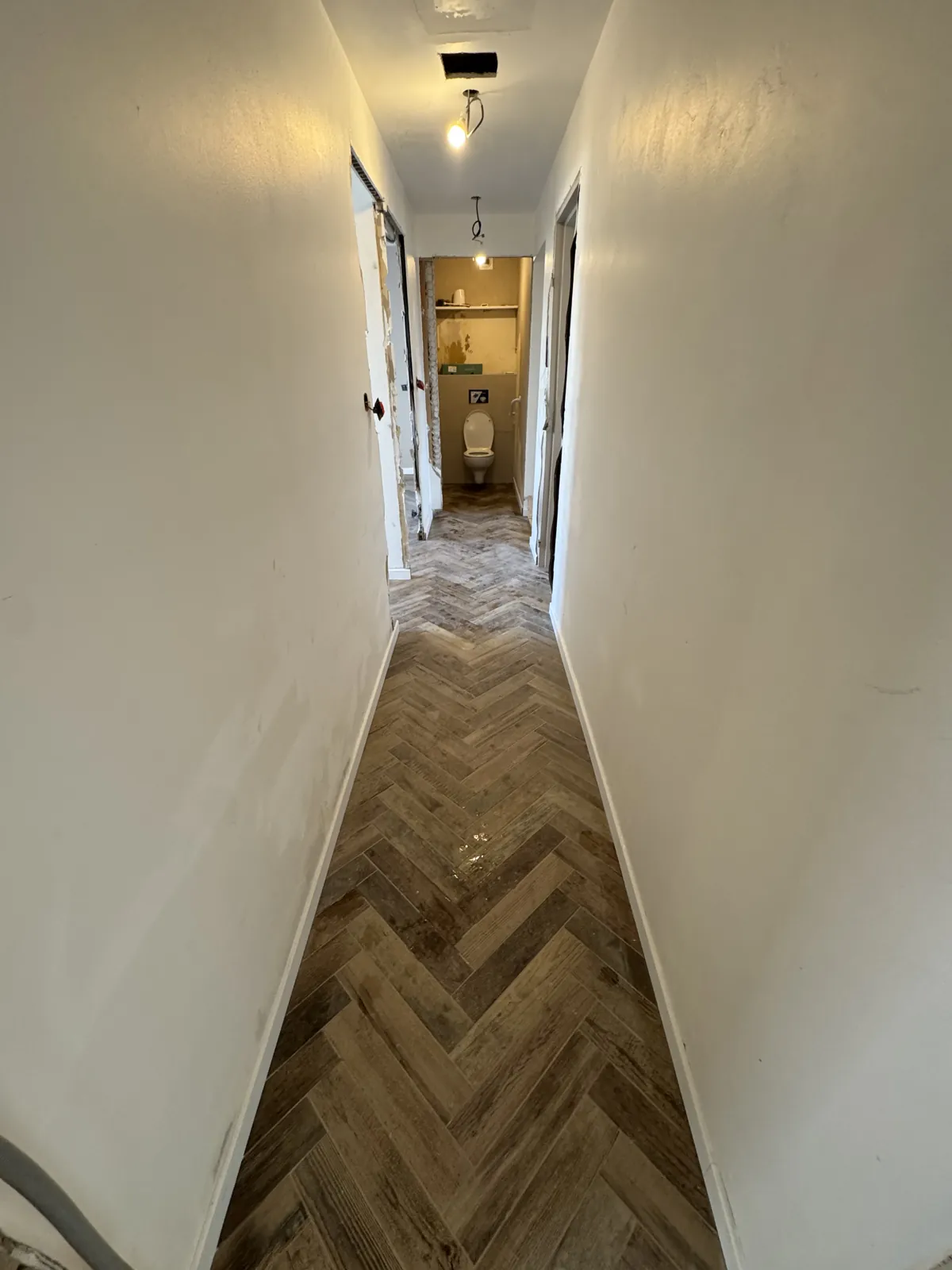Couloir carrelé en bâton rompu, imitation bois
