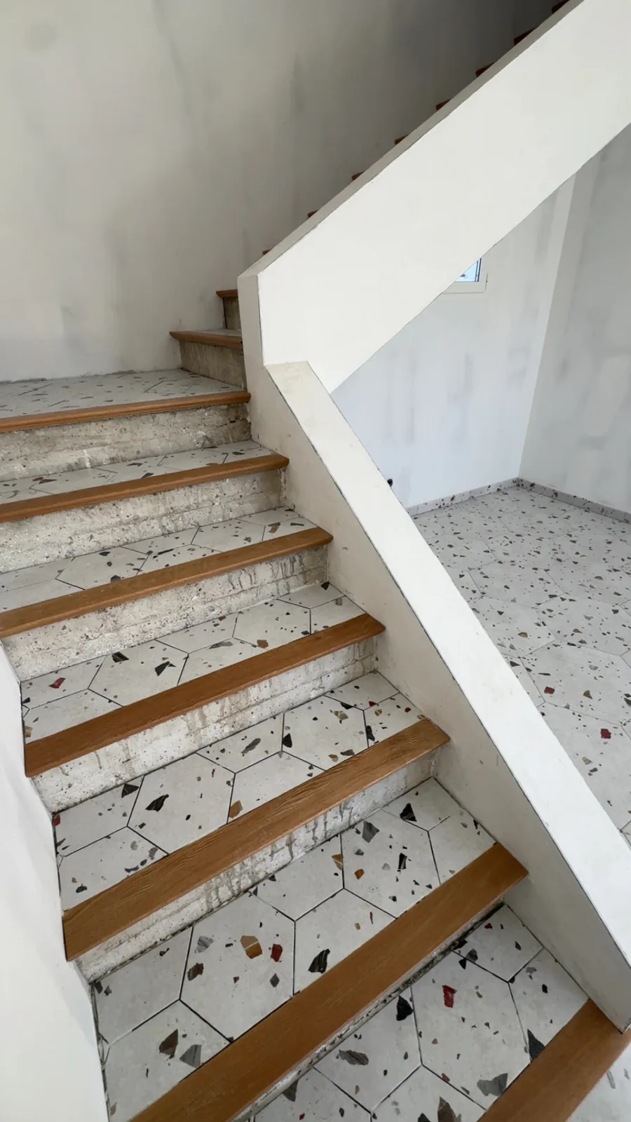 Escalier en carreaux hexagonaux mouchetés et nez de marche bois
